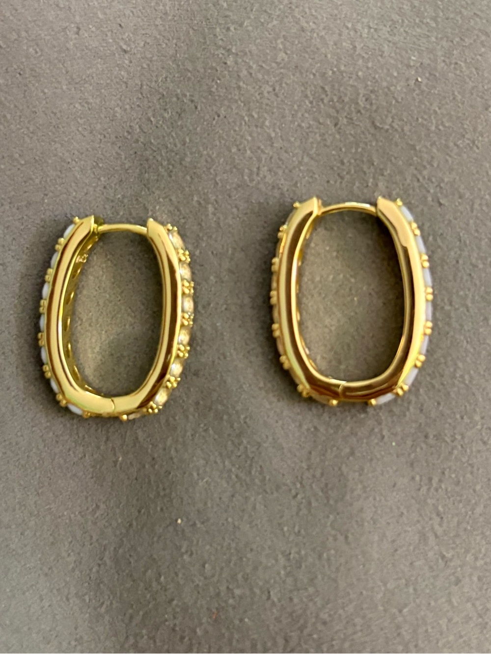 Kendra Scott Gold Oval Huggie Earrings with light blue and crystal Accents